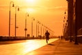 Silhouette of a man running on a boardwalk at sunset. Long Beach NY Royalty Free Stock Photo