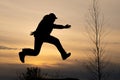 Silhouette of a man running in flight and silhouette of a tree without leaves Royalty Free Stock Photo