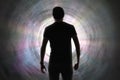 Silhouette of man`s soul is going to bright light - rays of god inside tunnel. Life after death concept. Royalty Free Stock Photo