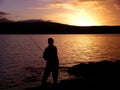 Silhouette of man sea fishing at sunset Royalty Free Stock Photo