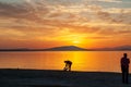 Silhouette of a man on the shore of the lake at sunset. Sunset over the sea with dramatic sky and reflection in the water Royalty Free Stock Photo