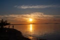 Silhouette of a man on the shore of the lake at sunset. Sunset over the sea with dramatic sky and reflection in the water Royalty Free Stock Photo