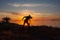 Silhouette of a man on the shore of the lake at sunset. Sunset over the sea with dramatic sky and reflection in the water Royalty Free Stock Photo