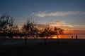 Silhouette of a man on the shore of the lake at sunset. Sunset over the sea with dramatic sky and reflection in the water Royalty Free Stock Photo