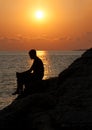 Man sitting on a rock and enjoying the sunset Royalty Free Stock Photo