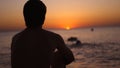 Silhouette of a man sitting alone on the beach looks sunset. Lonely, thinking person. Royalty Free Stock Photo