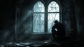 Silhouette of a Man Sitting Alone by a Window in a Dark Room Royalty Free Stock Photo