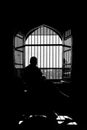 Silhouette of a man sitting in the dark against the window