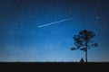 Silhouette of man sitting on mountain and night sky with shooting star. Alone concept. Royalty Free Stock Photo