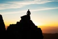 Silhouette Of Man Sitting On Top Of Mountain At Sunset Royalty Free Stock Photo