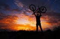 Silhouette the man stand in action lifting bicycle Royalty Free Stock Photo