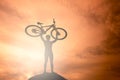 Silhouette the man stand in action lifting bicycle Royalty Free Stock Photo