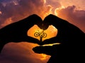 Silhouette the man stand lifting bicycle in hands heart shape Royalty Free Stock Photo