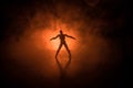 Silhouette of man standing on an dark foggy toned background. Decorated photo with man figure on table with light. Royalty Free Stock Photo