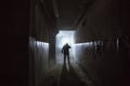 Silhouette of man in standing in dark scary corridor or tunnel with back light Royalty Free Stock Photo