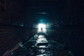 Silhouette of man standing in dark underground corridor. Light at end of tunnel concept