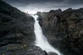 Silhouette of a man standing on the edge of mighty waterfall against dramatic sky. Stuor Muorkke waterfall in Stora Royalty Free Stock Photo