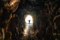 Silhouette man standing on end of natural cave, underground tunnel and light shines Royalty Free Stock Photo