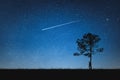 Silhouette of man standing on mountain and night sky with shooting star. Alone concept.