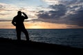 Silhouette of a man standing on the pier and looking at the sea during sunset Royalty Free Stock Photo