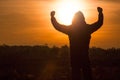 Silhouette of a man standing and rise his hands up in the air du Royalty Free Stock Photo