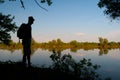Silhouette of the man standing on the river shore