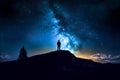 Silhouette of a man standing on top of a hill and looking at the milky way. Generative AI Royalty Free Stock Photo