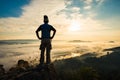 Silhouette man standing on top of the mountain watching the sun rise with fog Royalty Free Stock Photo