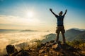 Silhouette man standing on top of the mountain watching the sun rise with fog