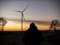 Silhouette of a man at sunset making a photo of wind turbines.wind power plants at sunset Royalty Free Stock Photo