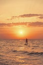 Silhouette of man on a SUP board in sea at sunset. Royalty Free Stock Photo