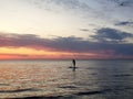 Silhouette of a man on the SUP ,Stand Up Paddle board, against the background of the colored sunset at sea Royalty Free Stock Photo