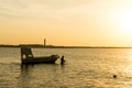 Silhouette of a man taking anchor for a boat with setting sun in the distance Royalty Free Stock Photo