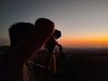 silhouette of man taking photo of sunset
