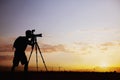 Silhouette of man taking photos with his camera at sunset with a dramatic sky Royalty Free Stock Photo