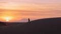 Silhouette of the man taking picture of the sunset in Dunes.
