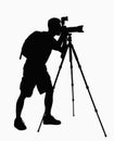 Silhouette of man taking pictures with camera on tripod. Royalty Free Stock Photo