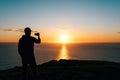 Silhouette of a man taking pictures of sunset Royalty Free Stock Photo