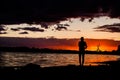 Silhouette of man with their hands in the sunset on the ocean Royalty Free Stock Photo