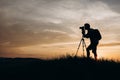 Silhouette of man with tripod taking pictures of sunset Royalty Free Stock Photo