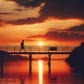 Silhouette of a man walking across a bridge against the background of a sunset. Royalty Free Stock Photo