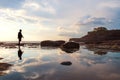 Silhouette a man walking with reflection on the water on the island Royalty Free Stock Photo