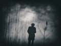 Silhouette man walking in tall grass. Royalty Free Stock Photo