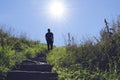 Silhouette of man walking up a stair towards the sun Royalty Free Stock Photo