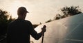 Silhouette of a man washing a solar power plant panel Royalty Free Stock Photo