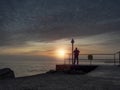 Silhouette of a man watching stunning sunset over ocean from a pier. Galway city, Ireland. Nature scene. Dark sky. Outdoor Royalty Free Stock Photo