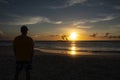 Silhouette of a Man Watching Sunset Over the Ocean Royalty Free Stock Photo