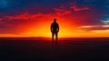 Silhouette of a Man Watching Vibrant Sunset Over Ocean Royalty Free Stock Photo
