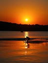 Silhouette of man on water skis at sunset