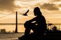 man wathing the panorama in lisbon portugal qith the famous 25th april suspension bridge on sunset background Royalty Free Stock Photo